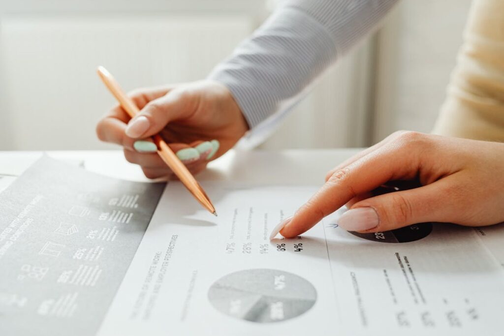 Planejamento-financeiro-Duas mãos femininas sobre o papel que contem alguns gráficos